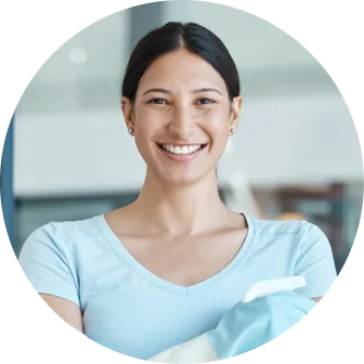 A smiling caretaker holding cleaning supplies