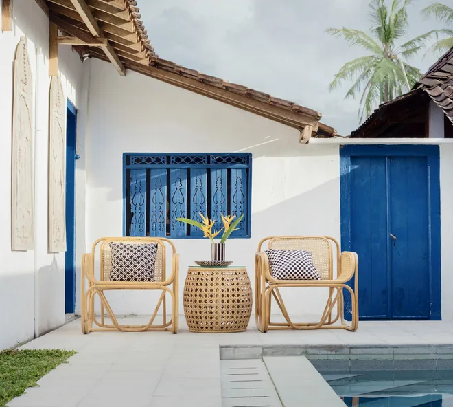 A whitewashed courtyard with cane chairs and cobalt blue doors