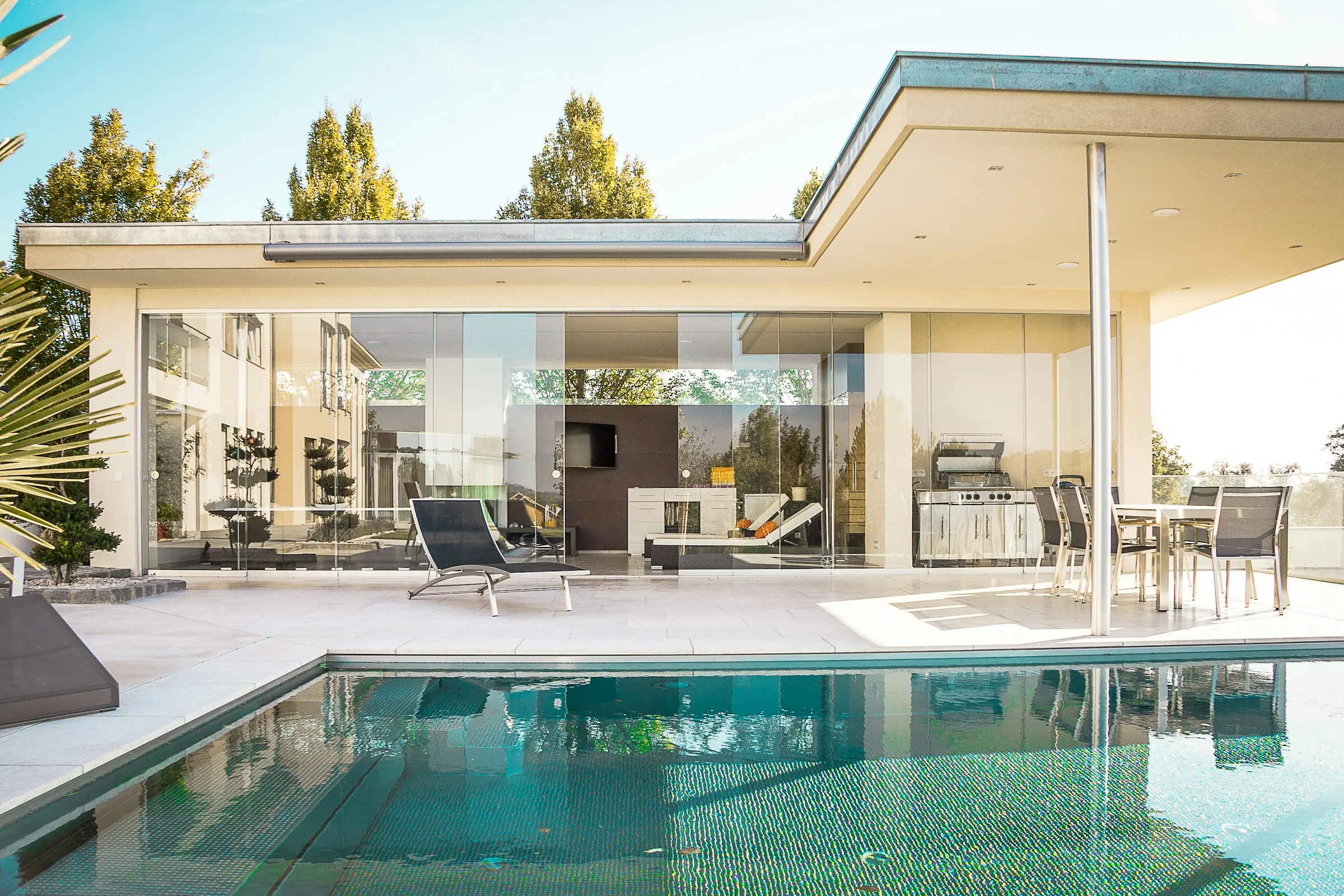 A flat-roofed modern home beside a turquoise pool