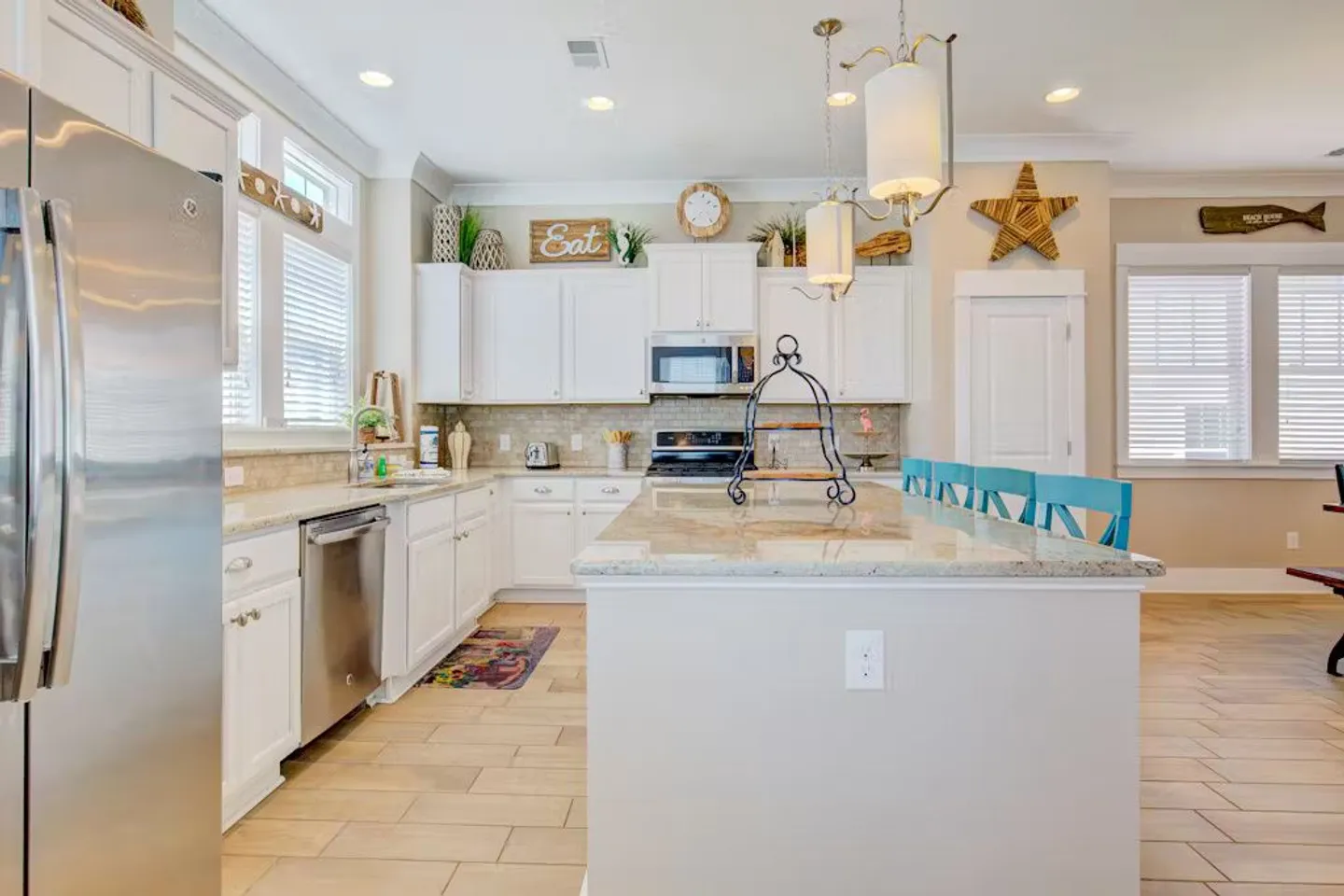 Bright kitchen featuring white cabinets, stainless steel appliances, and a center island with counter seating.