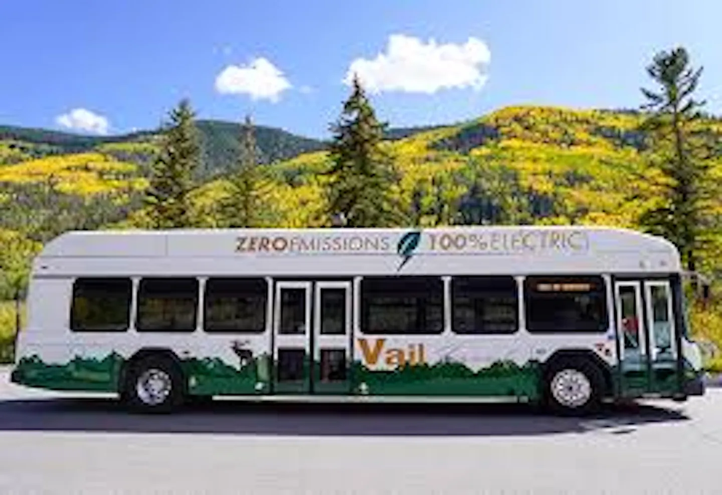 A Town of Vail zero-emissions electric transit bus parked against a backdrop of autumn-colored mountain slopes.