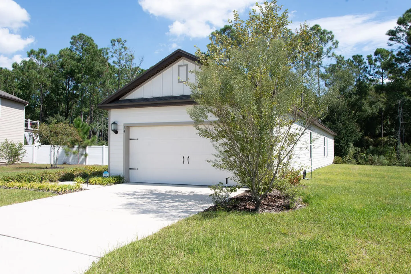Exterior view of an attached garage and paved driveway under a blue sky.