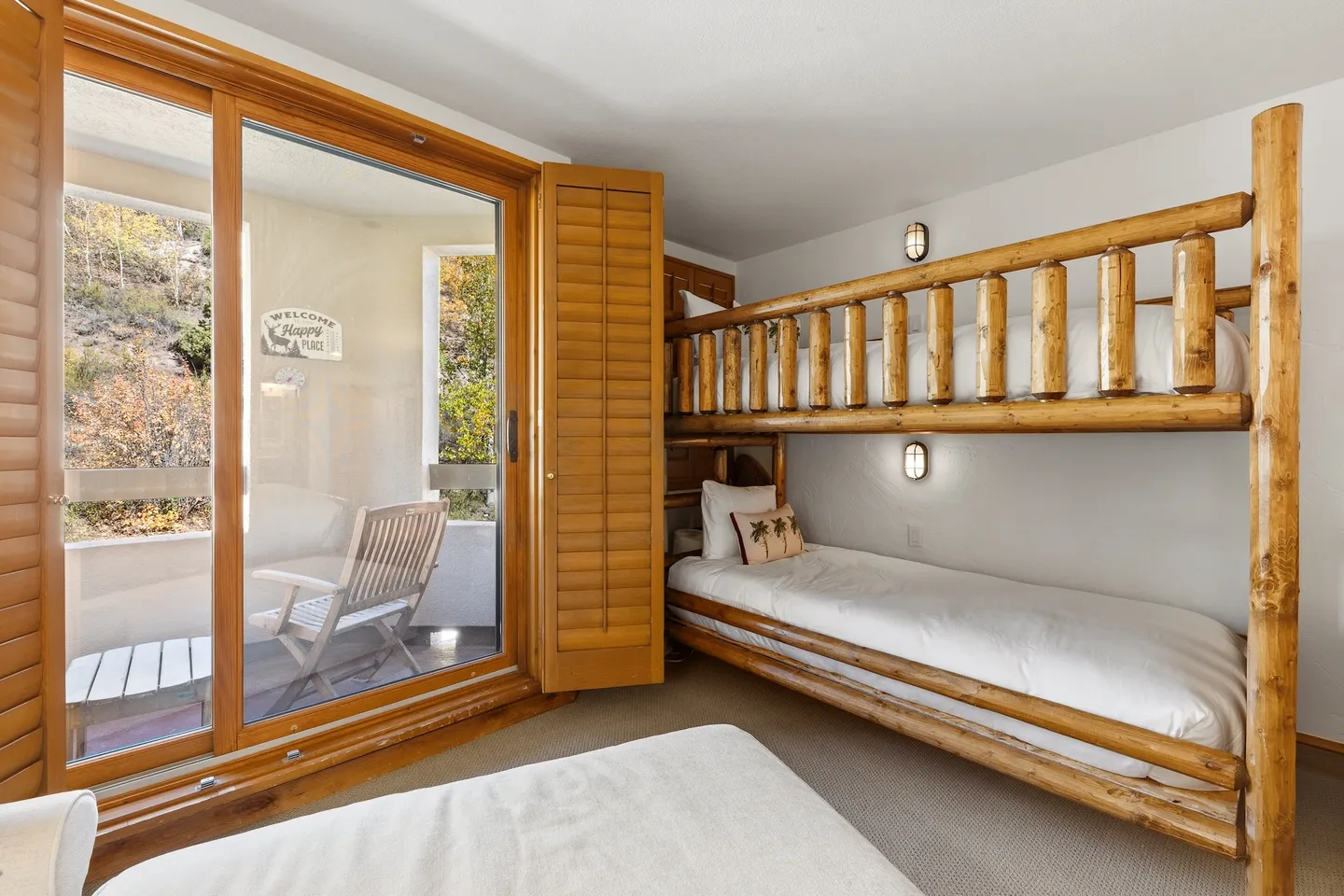 Bedroom featuring rustic wooden bunk beds and sliding glass doors opening to a private balcony.