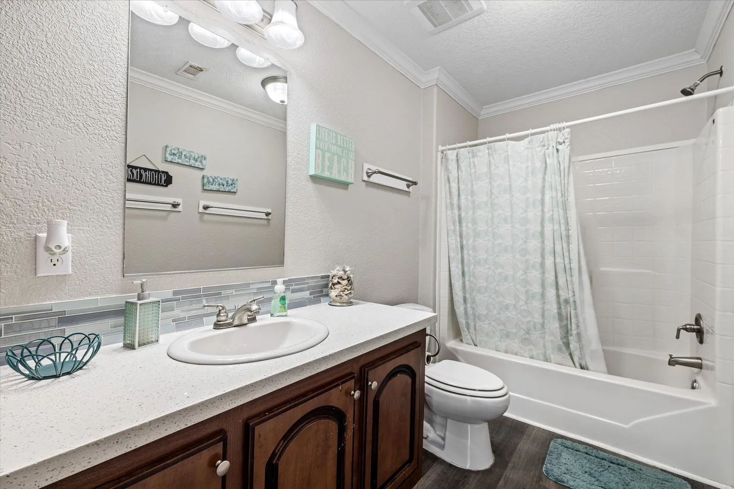 Bathroom featuring a vanity with a white countertop, toilet, and combination bathtub and shower with a curtain.