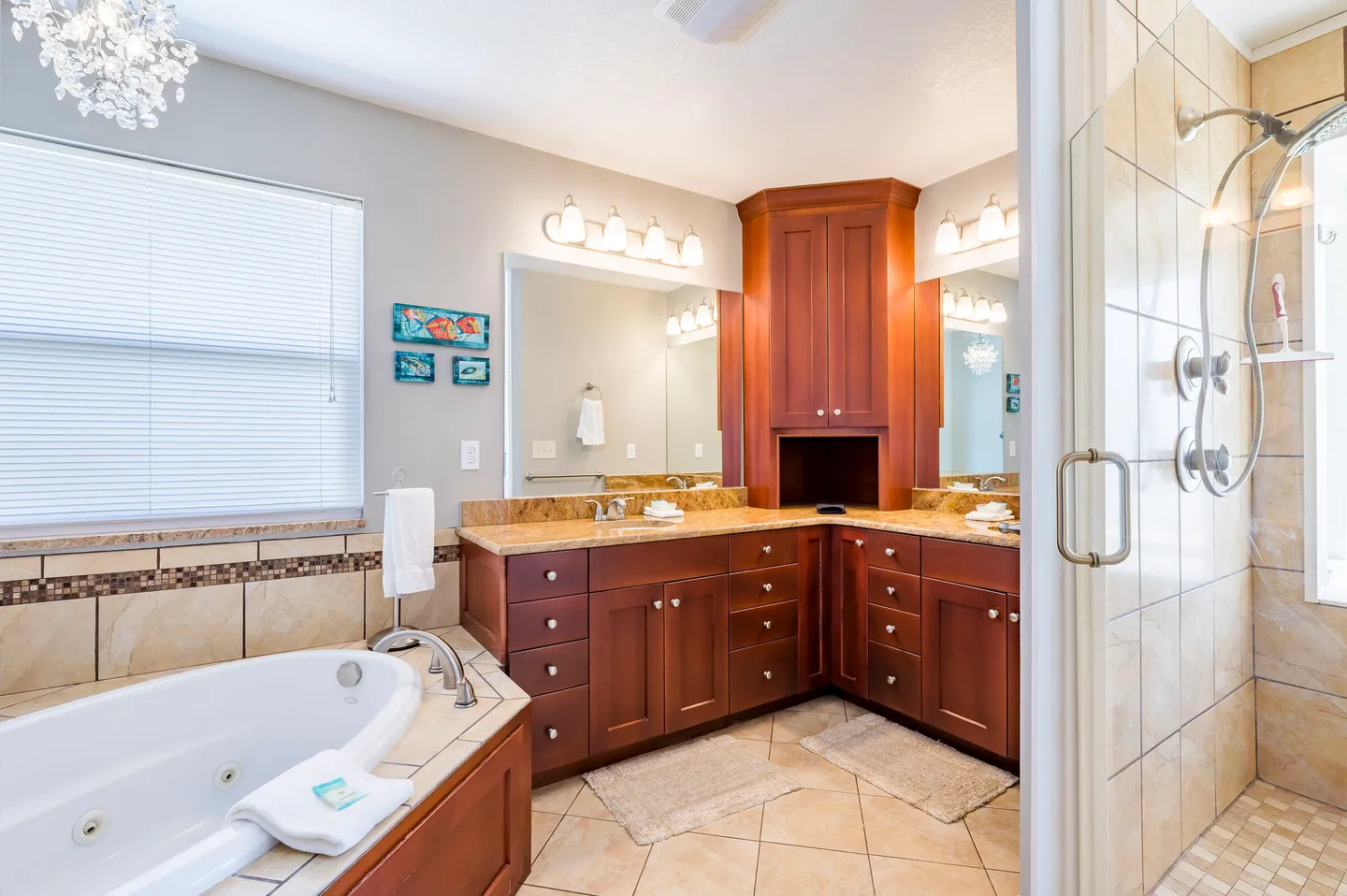 Primary bathroom featuring an L-shaped wood vanity, a built-in soaking tub, and an adjacent walk-in tiled shower.