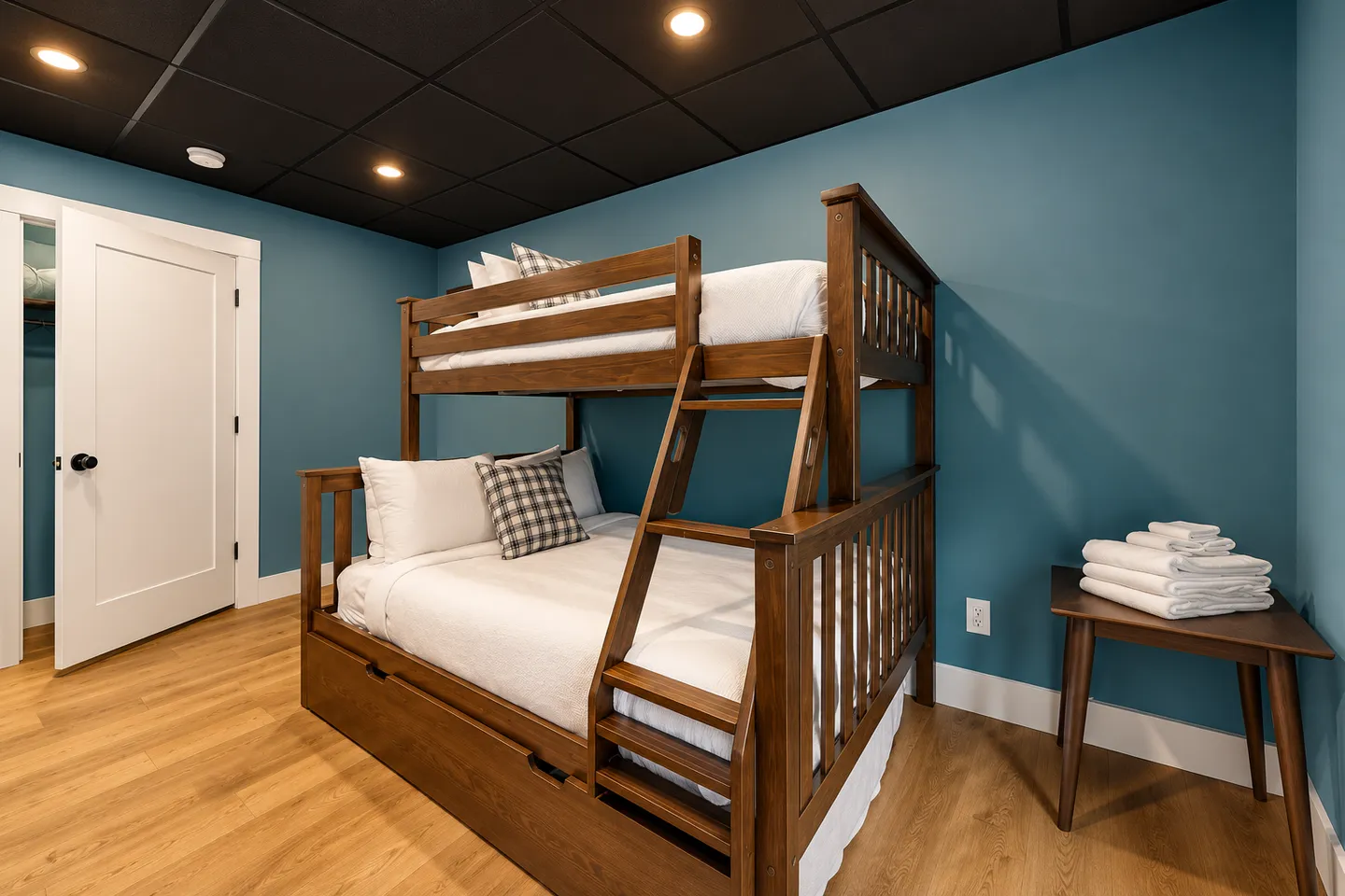Bedroom featuring a wooden bunk bed with white bedding against a teal-blue wall and a dark tiled ceiling with recessed lights.