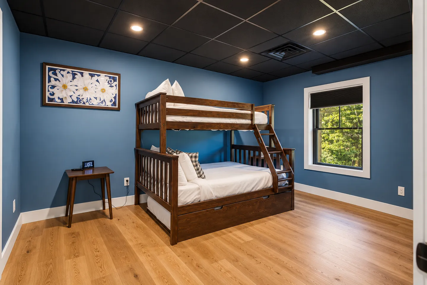 Bedroom with blue walls, dark tiled ceiling, light wood-style floors, and a wooden bunk bed with an attached ladder.