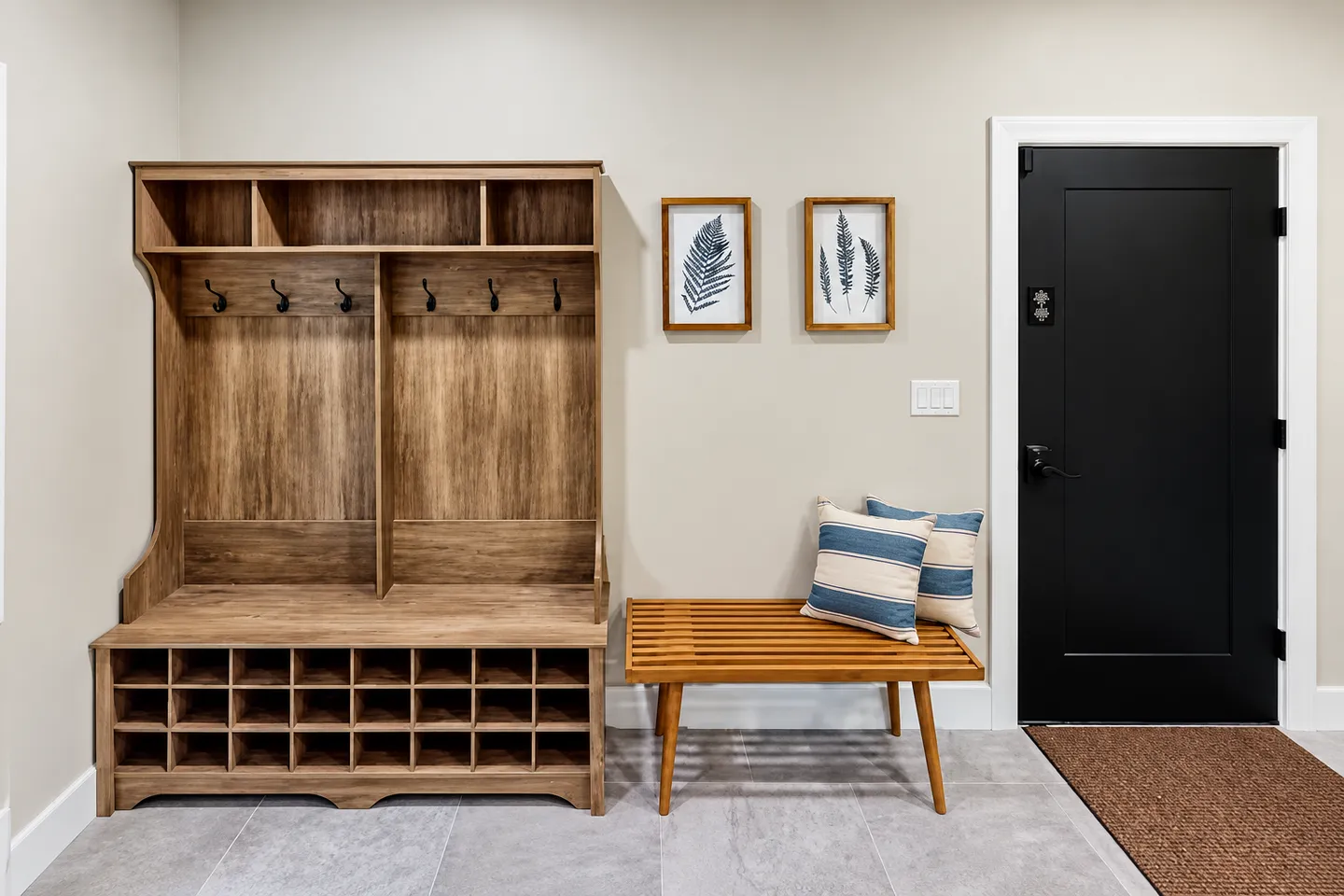 Entryway mudroom area featuring a large wooden hall tree with cubbies, a slat bench, and a black exterior door.