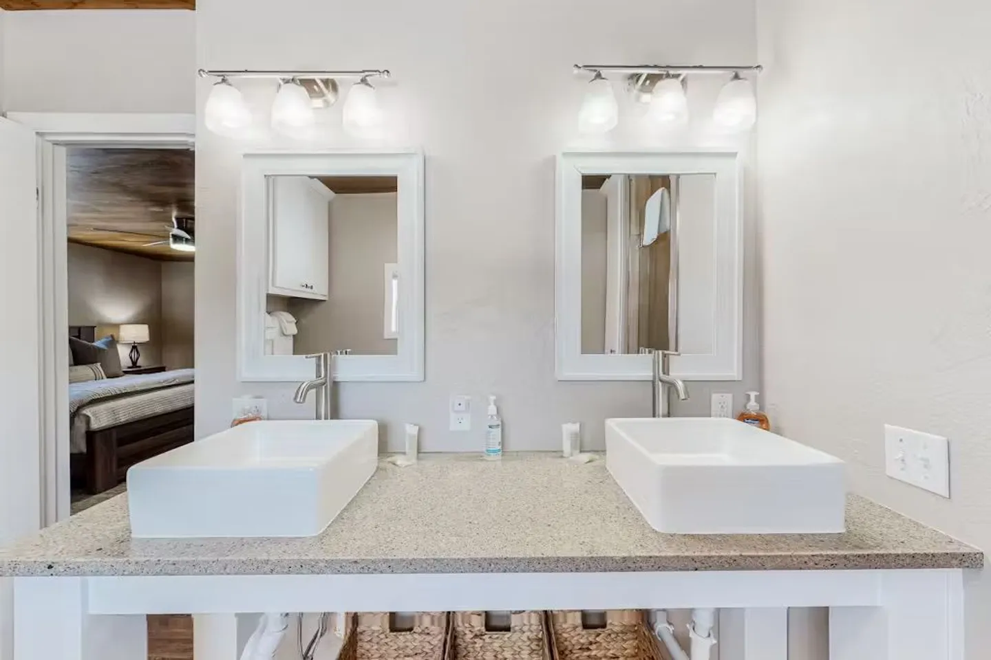 Bathroom vanity featuring two white rectangular vessel sinks, matching mirrors, and modern lighting fixtures.