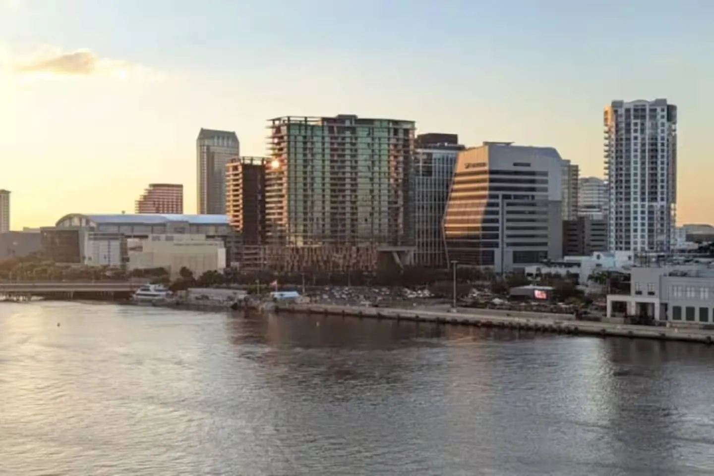 City skyline with high-rise buildings and waterfront at sunset.