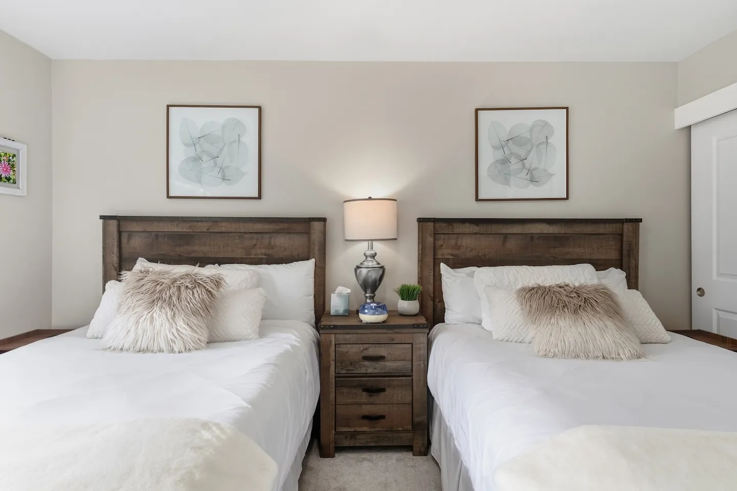 Bedroom with two beds featuring matching rustic wooden headboards and a nightstand between them.