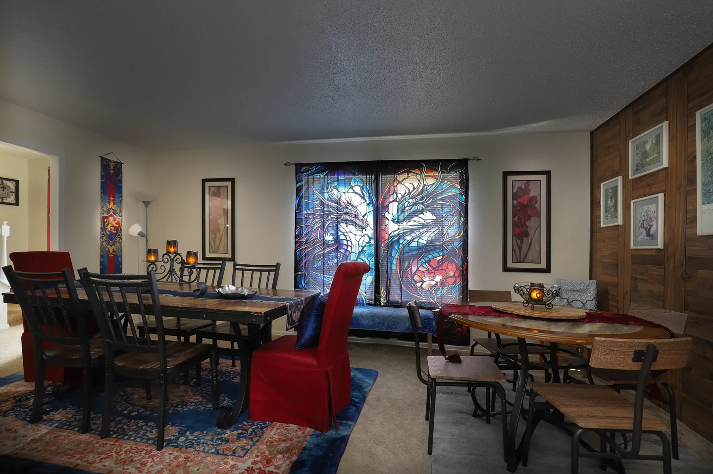 Dining area featuring two dining sets, patterned window curtains, and decorative wall art.