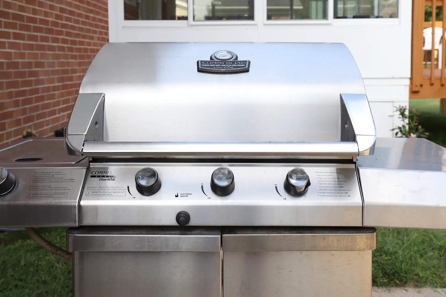 Close-up view of a stainless steel outdoor gas grill situated on a patio.