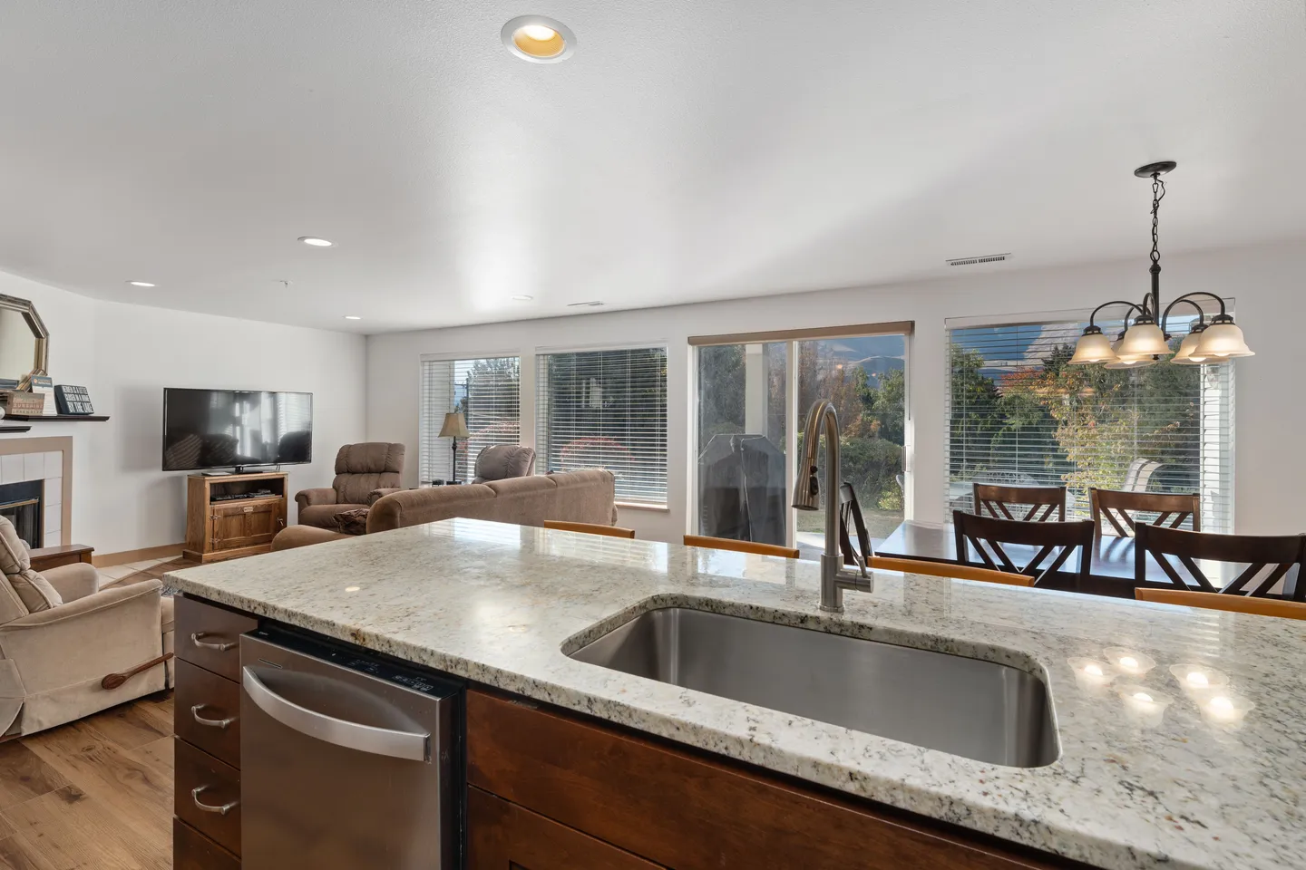 Open-concept kitchen island with an undermount sink overlooking the dining area and living room.