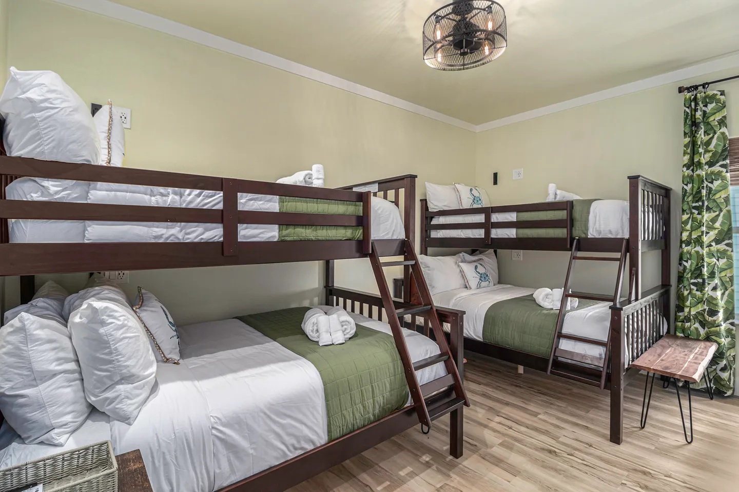 Bedroom featuring two sets of dark wood bunk beds with light bedding and green accents.
