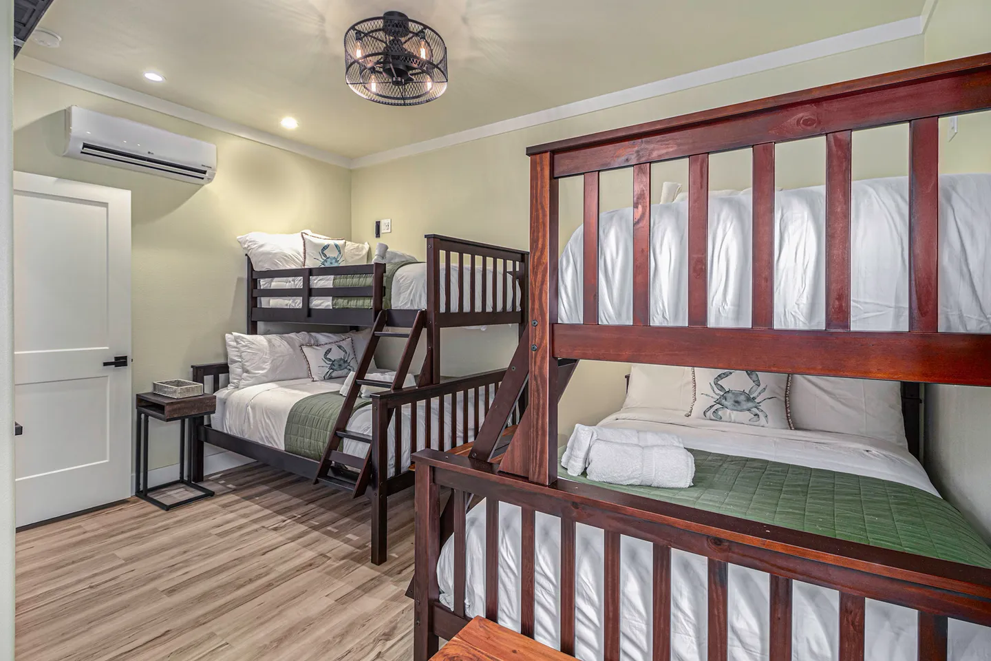 Bunk bedroom featuring two sets of dark wood bunk beds with white linens and a cage-style ceiling fan.
