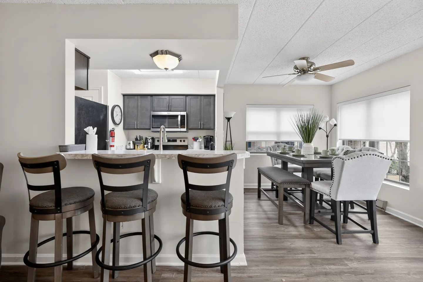 Open view from a breakfast bar with high stools to the kitchen and adjacent dining area.