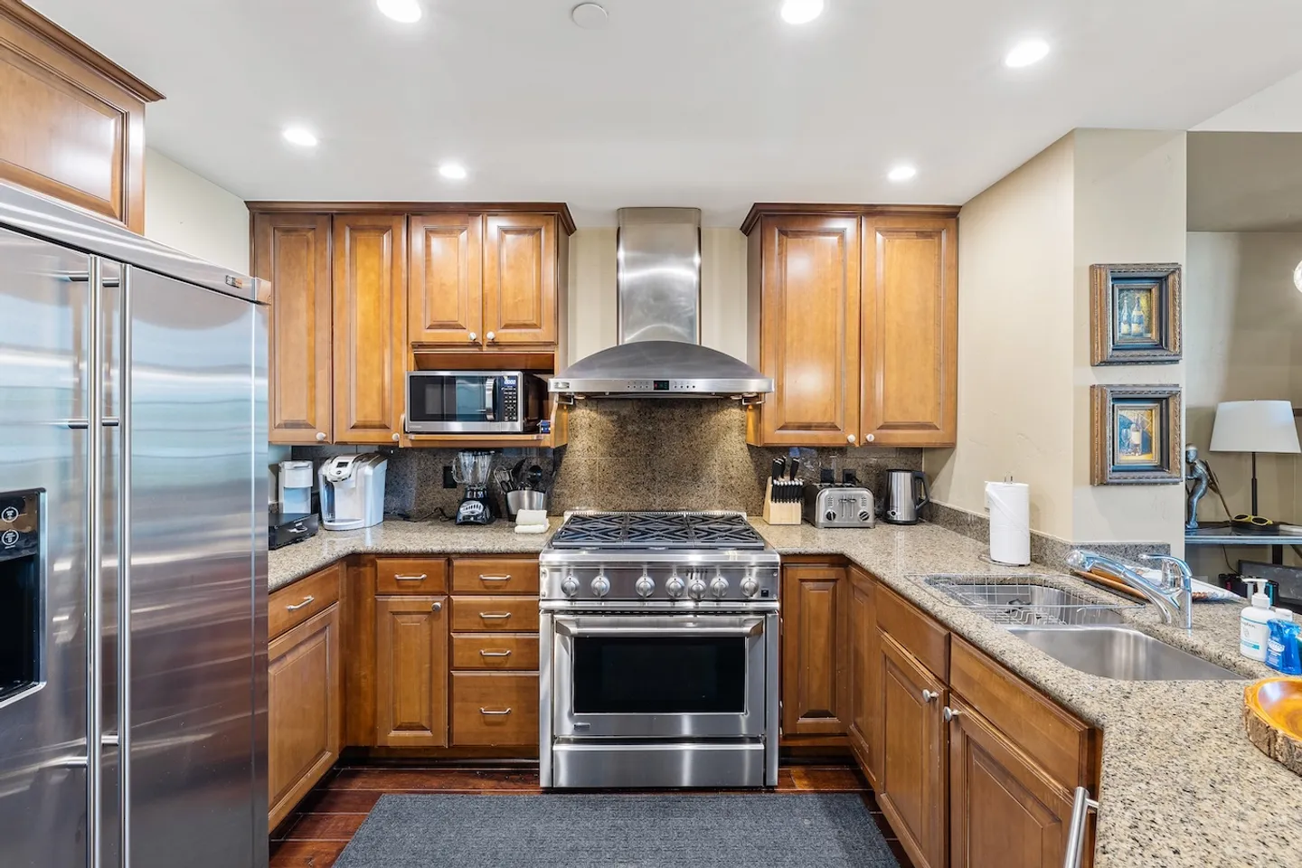 Kitchen with stainless steel appliances, dark wood cabinets, and granite countertops.