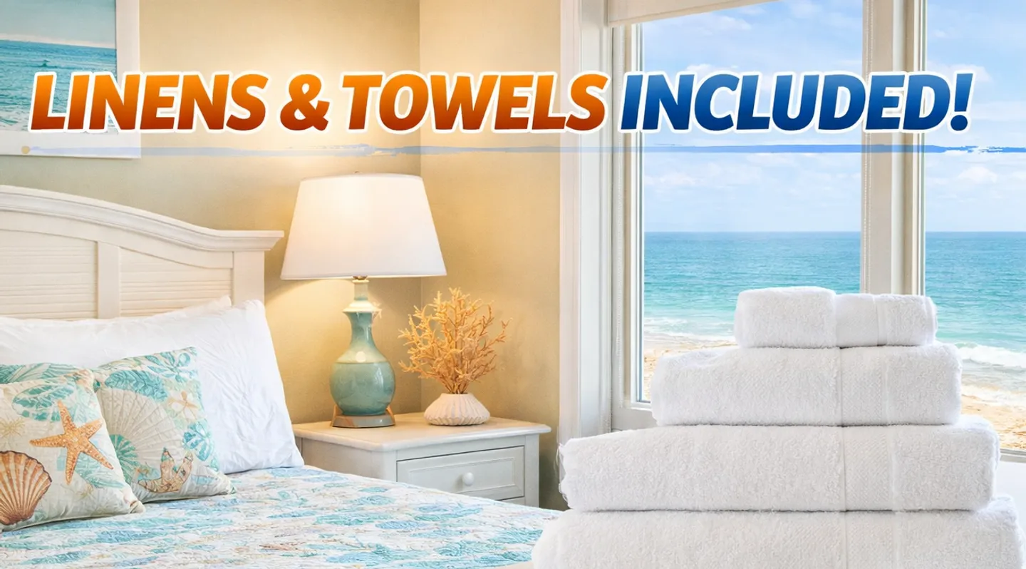 Bedroom with coastal-themed bedding, a stack of white folded towels, and a window overlooking the ocean, overlaid with text reading LINENS & TOWELS INCLUDED!