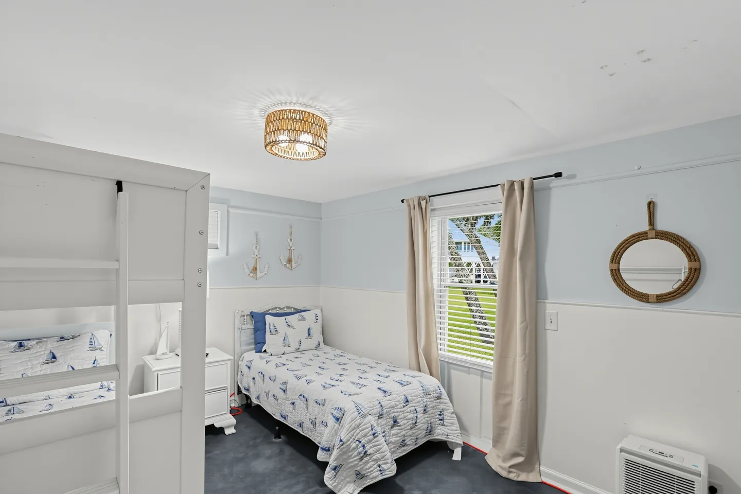 Bedroom with nautical decor featuring a twin bed, bunk beds, blue carpeting, and a window.