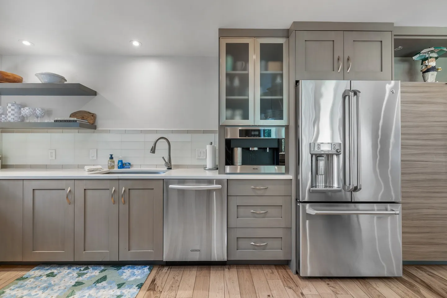 Kitchen counter and cabinets featuring stainless steel appliances including a refrigerator, dishwasher, and built-in coffee maker.