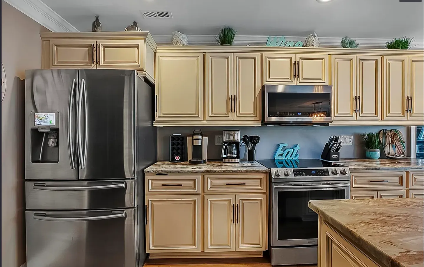 Kitchen counter and cabinets featuring stainless steel appliances including a refrigerator, range, and built-in microwave.