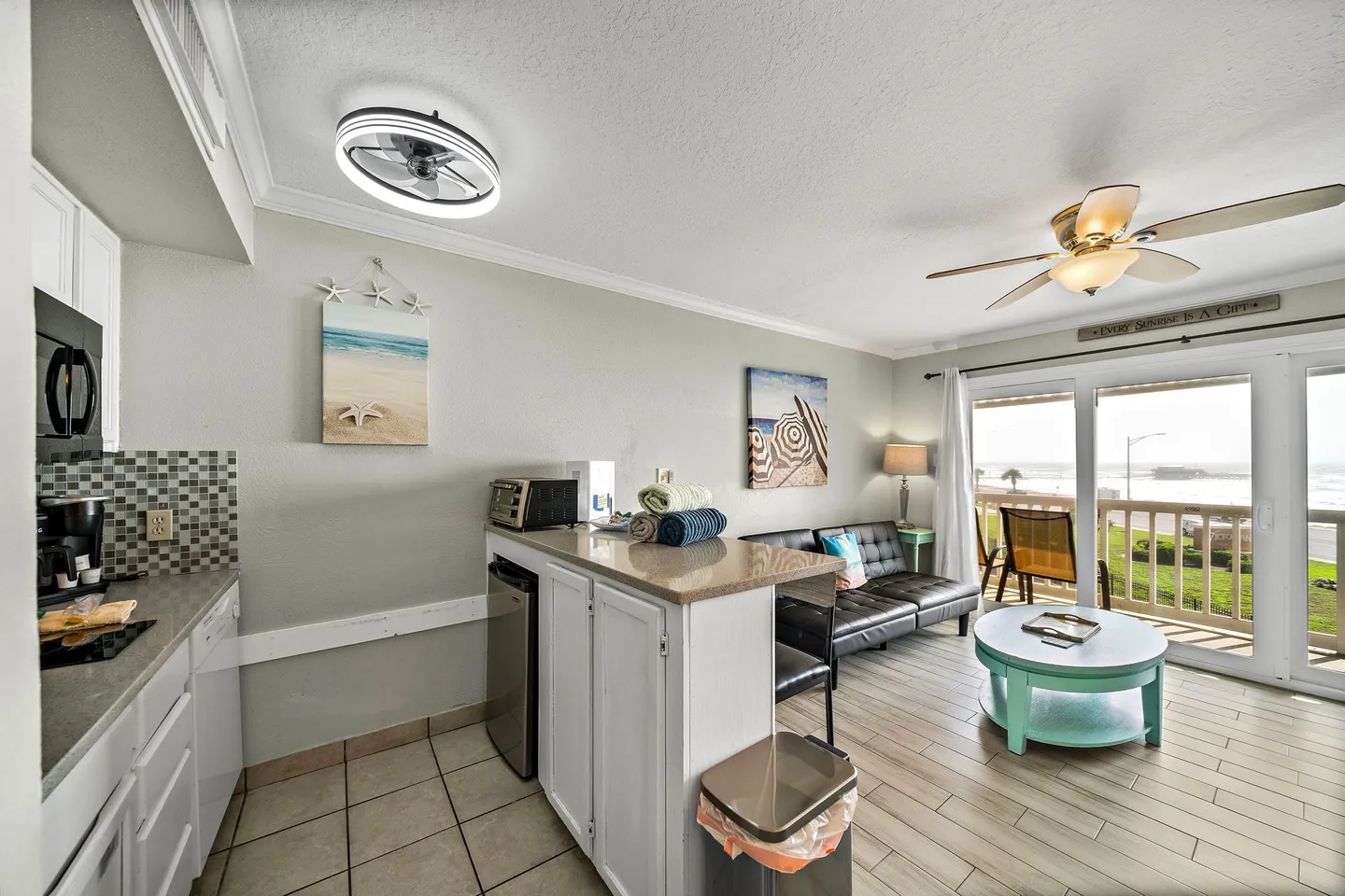 Open-concept kitchenette and living area leading to a balcony through sliding glass doors.