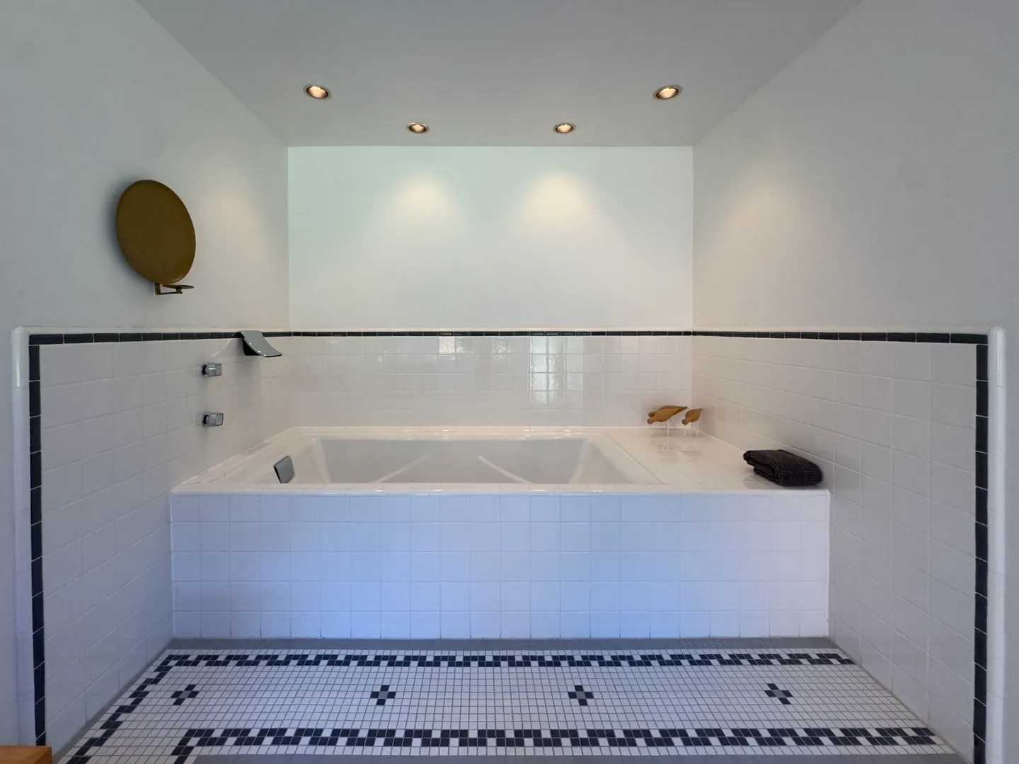 Bathroom alcove featuring a built-in tiled soaking tub, recessed ceiling lights, and patterned floor tile.