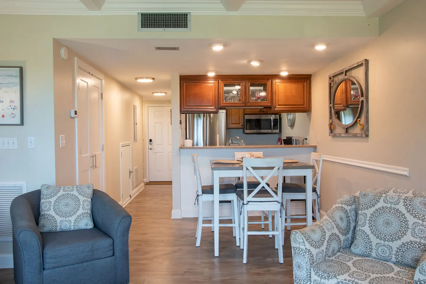 Open-concept living and dining area leading to a kitchen with wooden cabinets and stainless steel appliances.