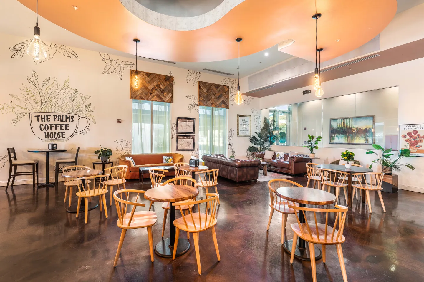 Lounge and cafe area labeled 'The Palms Coffee House' with round wooden tables, light wood chairs, leather sofas, and pendant lighting.