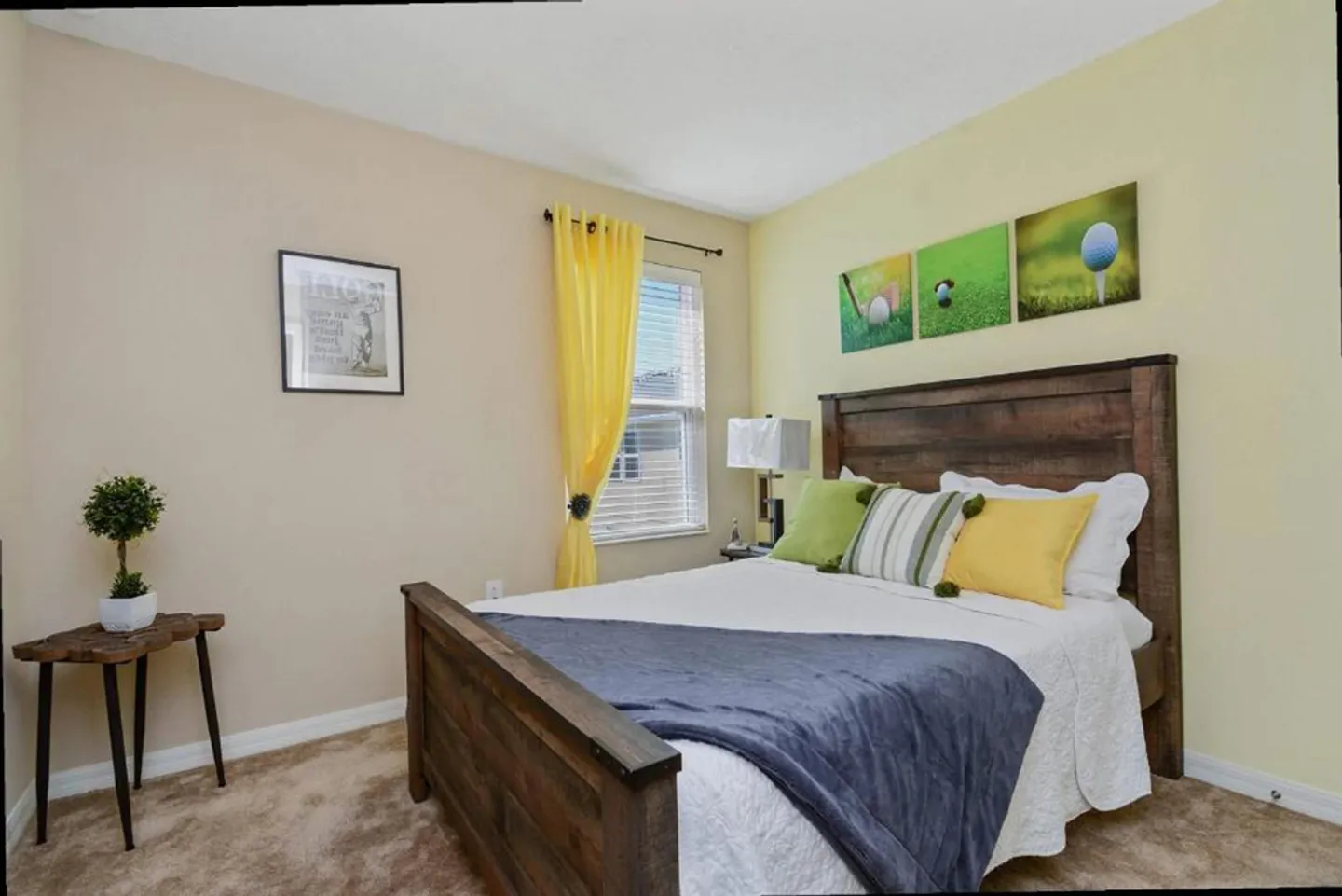 Bedroom featuring a dark wood-toned bed, carpeted flooring, a small window with yellow curtains, and golf-themed artwork.