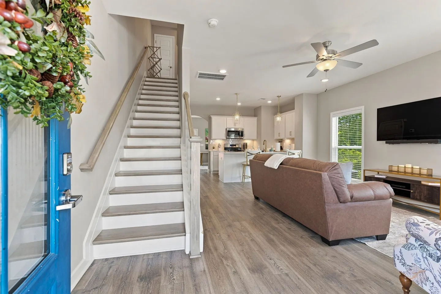 Open-concept entryway looking toward the living room, staircase, and kitchen in the background.