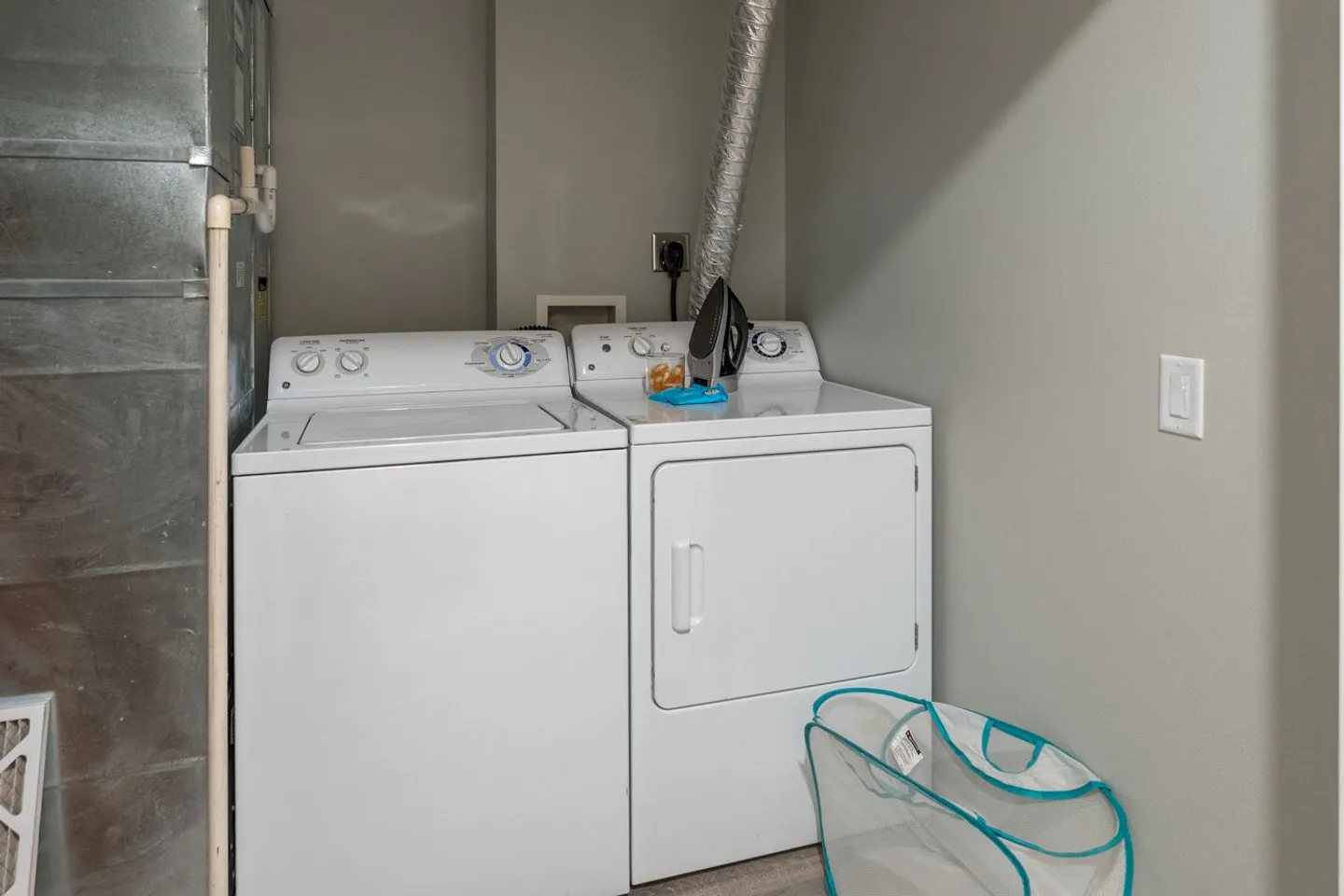 A laundry closet featuring a white washing machine and a white front-loading dryer side by side.