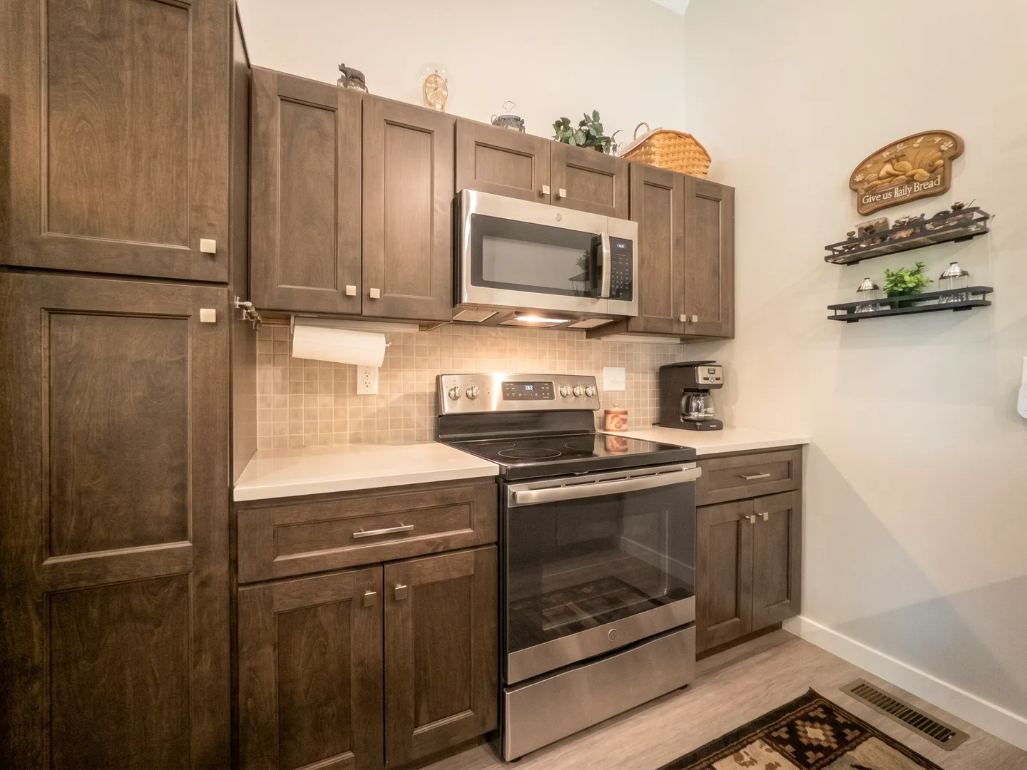 Kitchen counter area with dark wood cabinets, stainless steel range, and built-in microwave.
