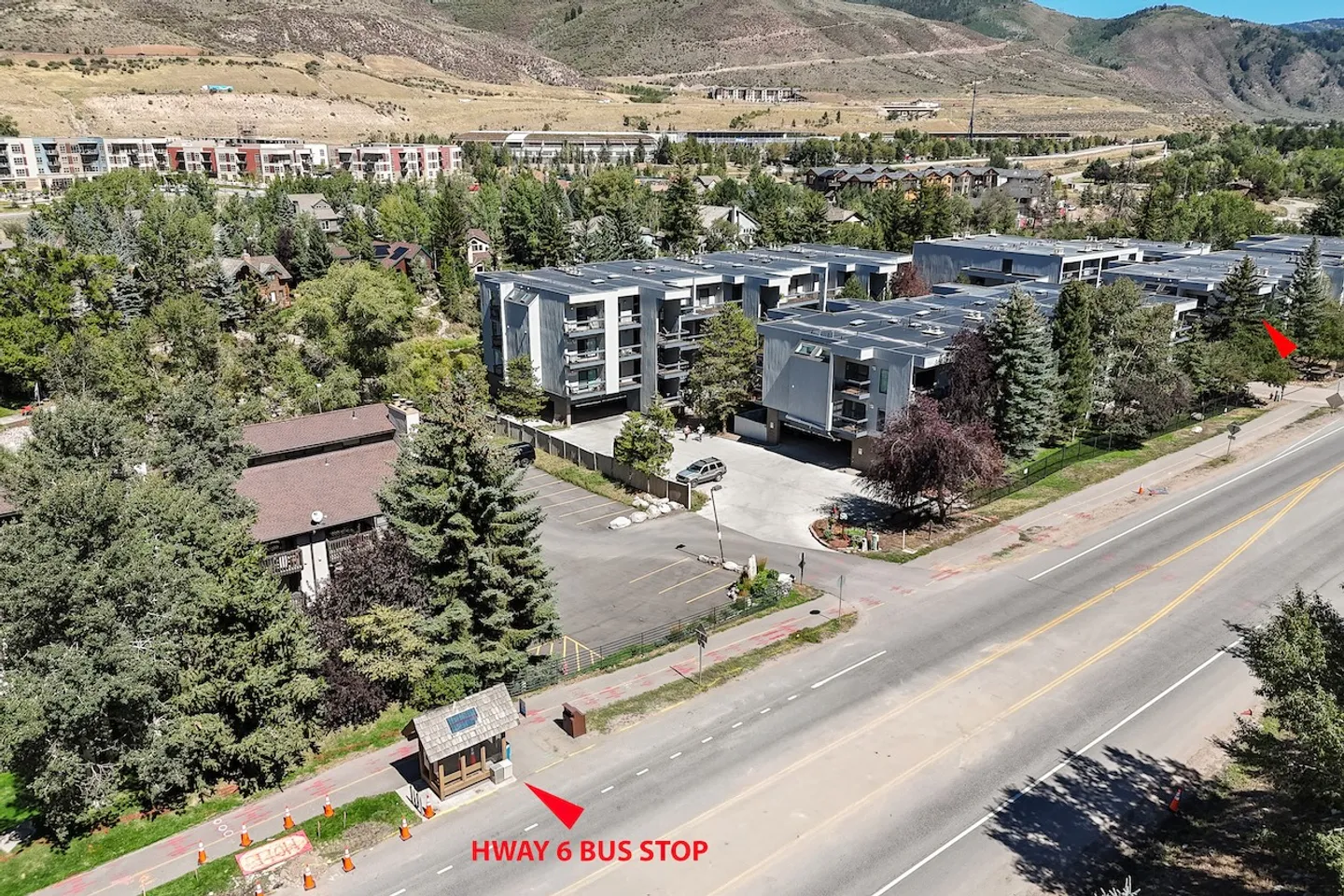 Aerial view of a condominium complex and a roadside bus stop labeled HWAY 6 BUS STOP.