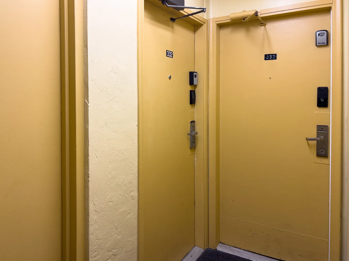 Yellow hallway doors numbered 332 and 333 with electronic keypads and door handles.