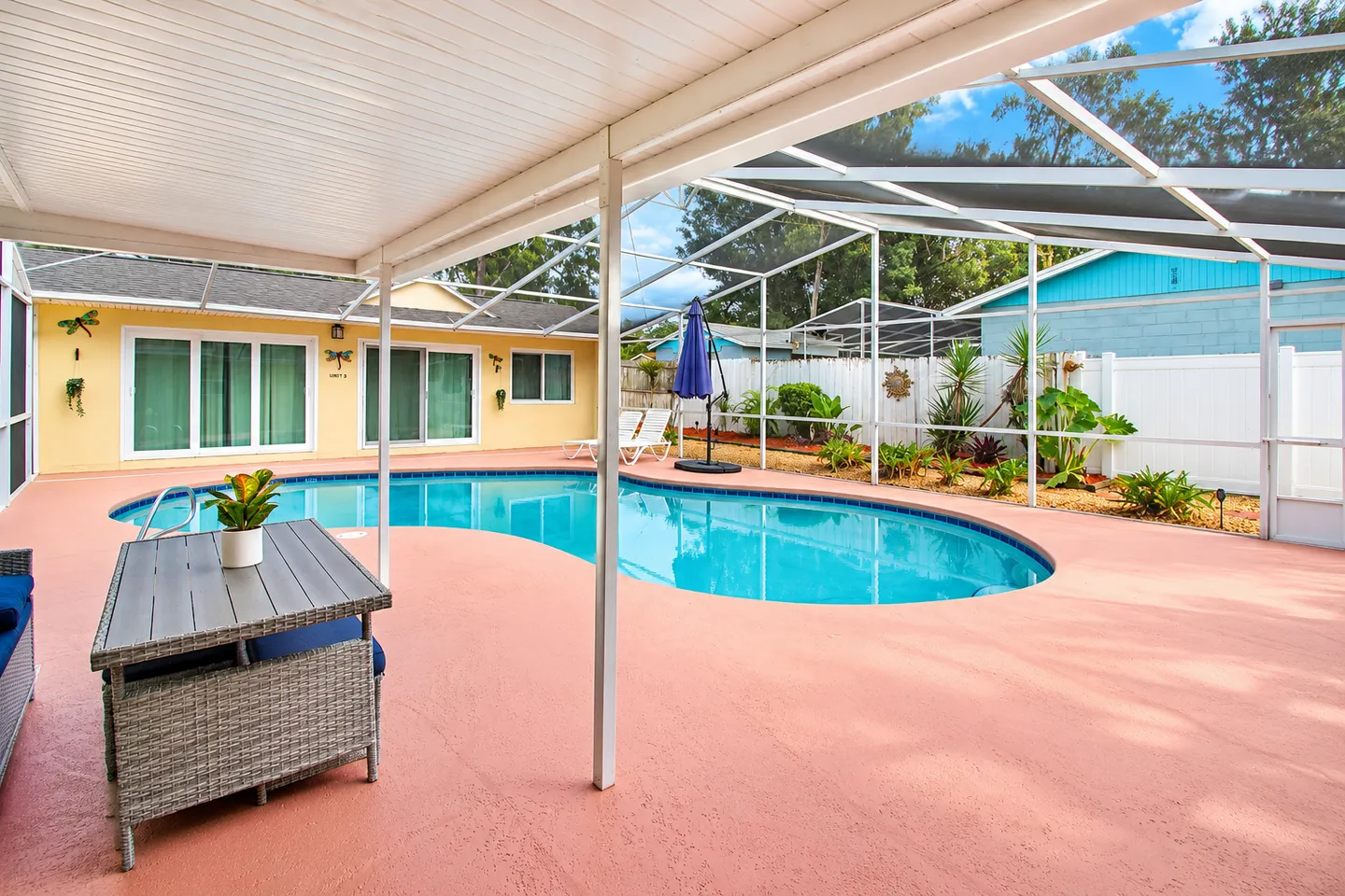 Screened-in backyard patio and swimming pool with outdoor seating under a covered porch area.
