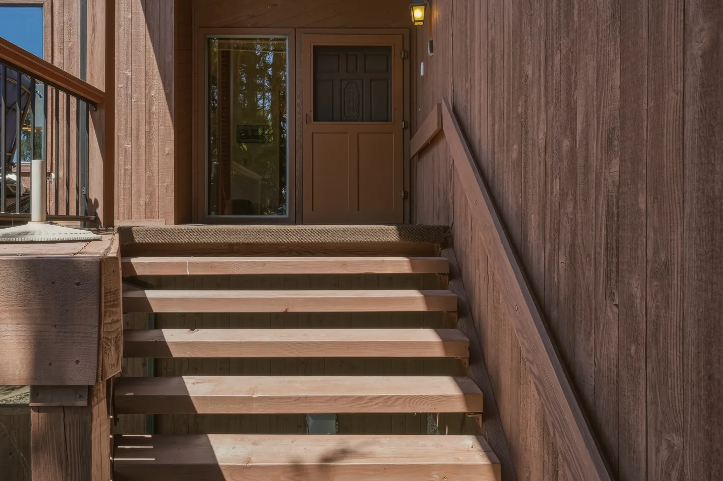 Outdoor wooden staircase leading up to an entry door and front landing.