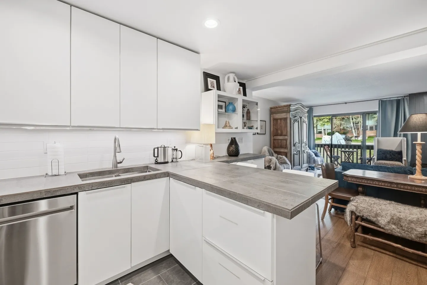 Kitchen counter and cabinets looking toward an open dining area and sliding glass patio door.