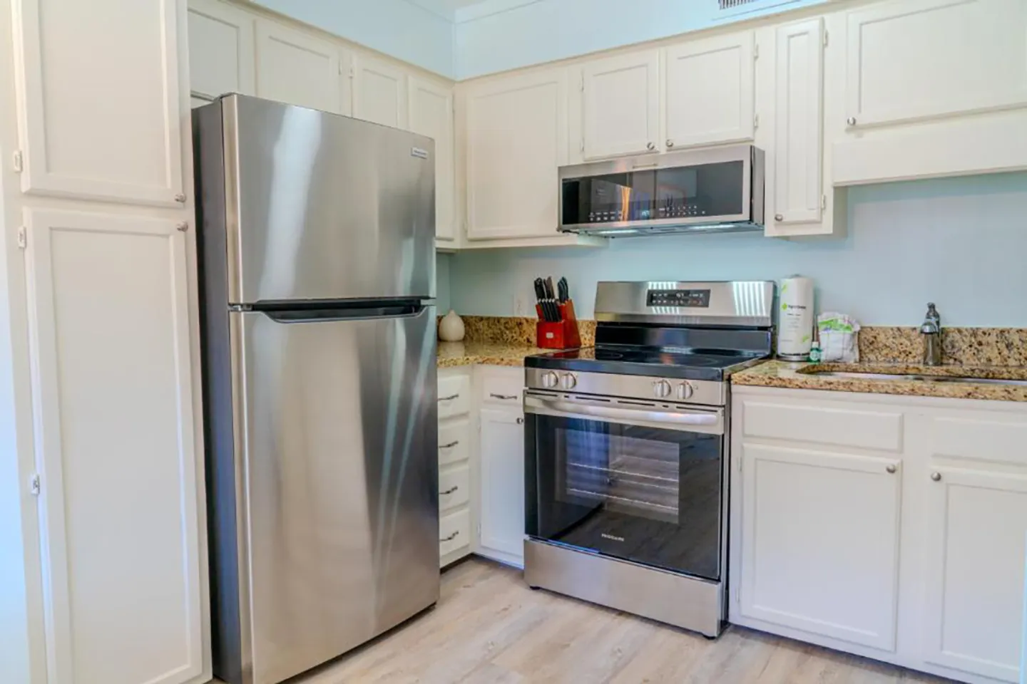 Kitchen interior featuring stainless steel appliances and white cabinetry.
