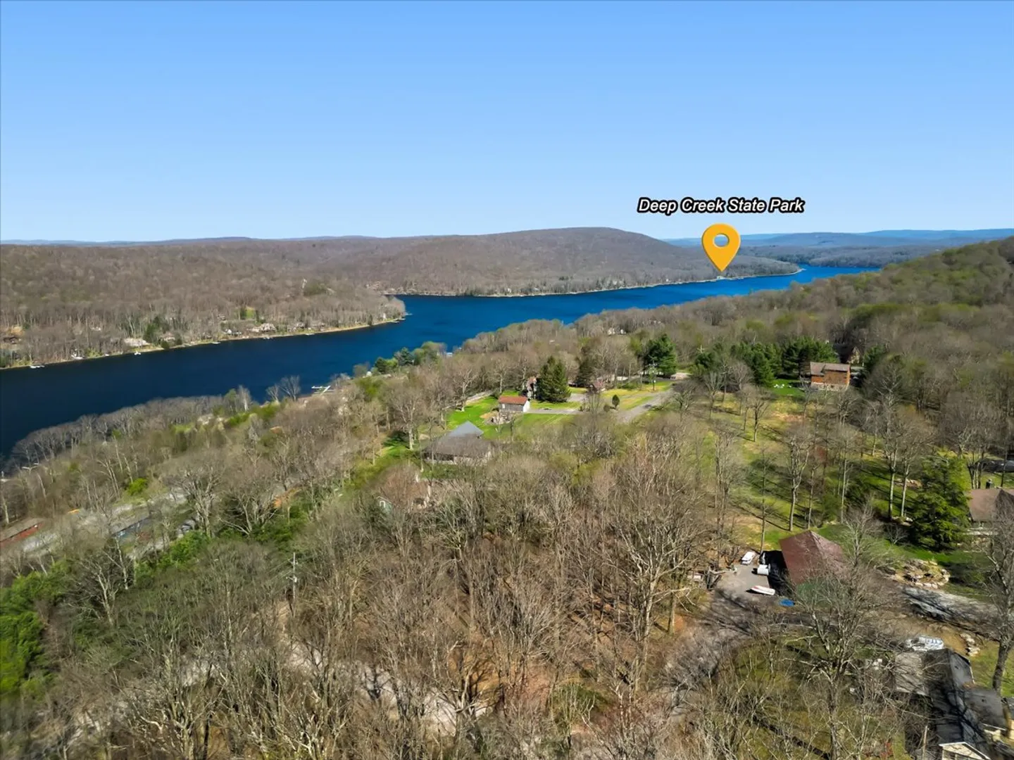 Aerial view of a wooded neighborhood near a wide lake with Deep Creek State Park labeled in the distance.