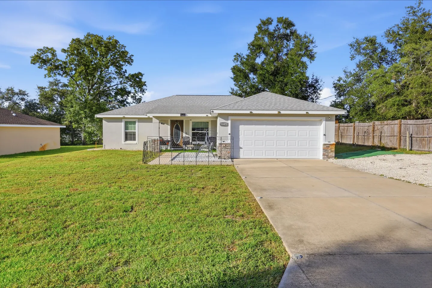 Exterior front view of a single-story home with a two-car garage, concrete driveway, and front lawn.