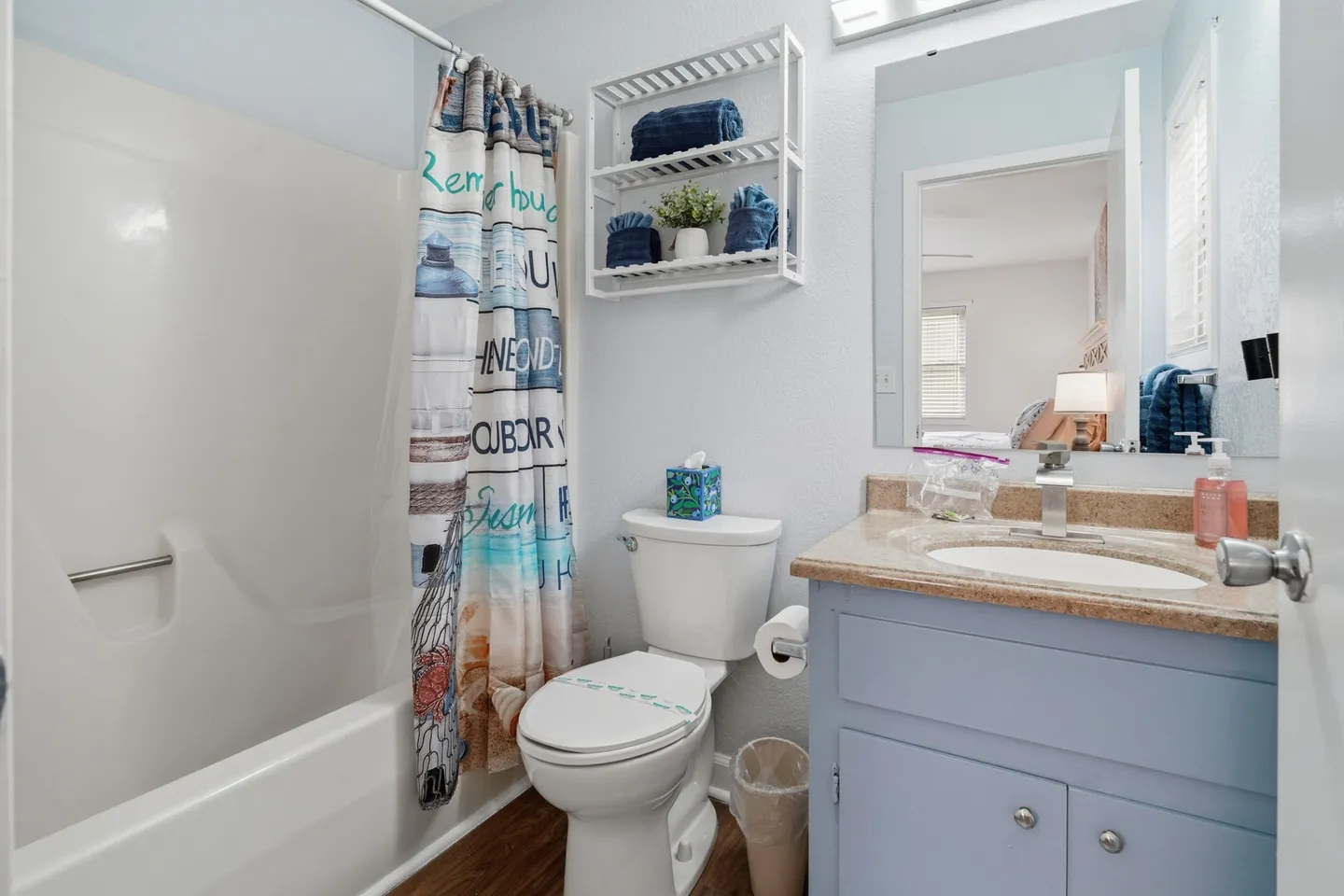 Bathroom with a bathtub shower combination, toilet, and vanity sink with a mirror.
