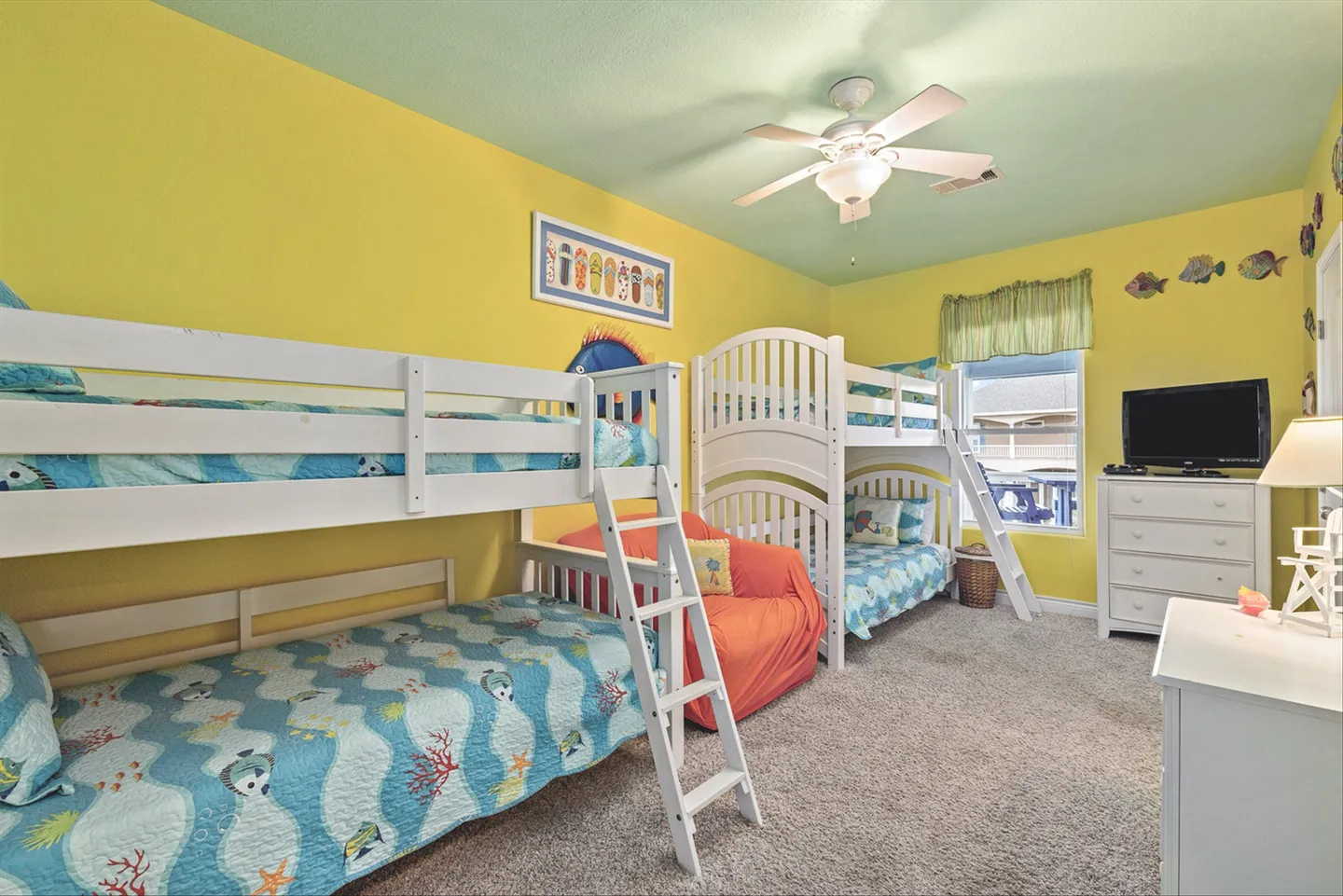Bedroom with yellow walls, light green ceiling, and two sets of white bunk beds.